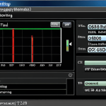 **Image:** A close-up of a computer screen displaying an SSD health monitoring tool (e.g., CrystalDiskInfo) with temperature and SMART status clearly visible. The setting is a typical home office.